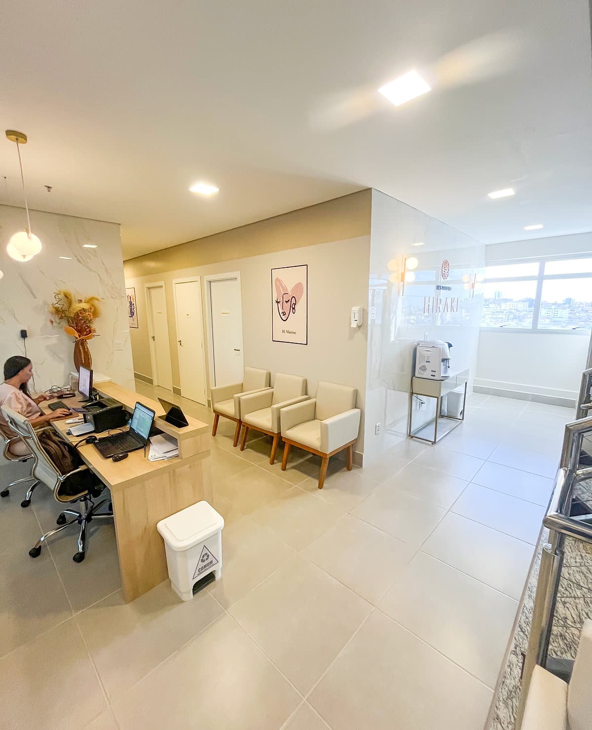 Sala de espera da unidade Prado do Instituto Hiraki com balcão de atendimento e poltronas