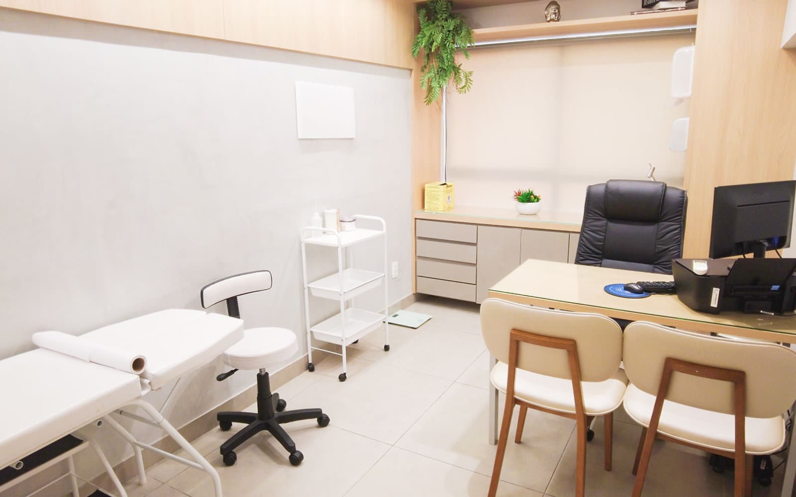 Sala de procedimentos da unidade Lourdes do Instituto Hiraki com maca, mocho, carrinho auxiliar e mesa de atendimento